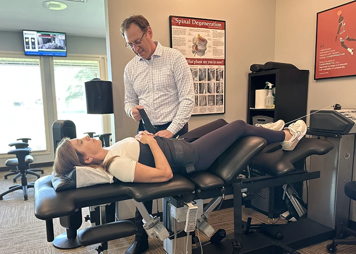 Matthew Kirkham Performing Spinal Decompression on a Woman Face Up